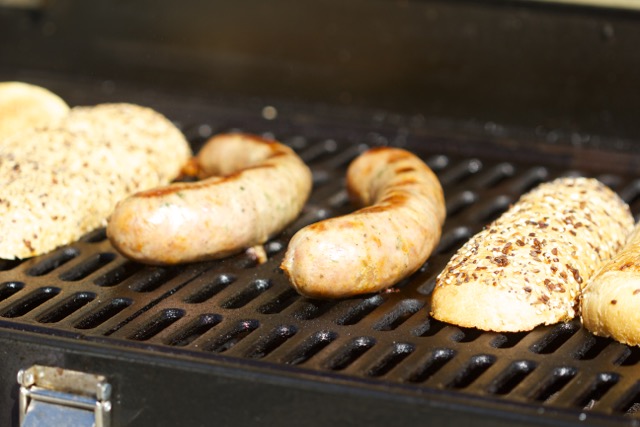 Homemade sausage with buns on the grill
